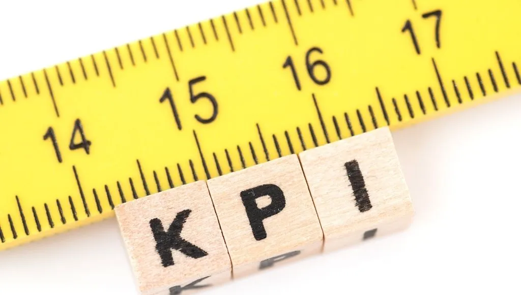 ahşap harf küpleri KPI yazısını oluştuyor, küplerin üzerinde metre var